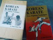 Twee exemplaren van het boek Korean Karate Free Fighting Techniques van Sihak Henry Cho, één met een witte en één met een rode kaft.